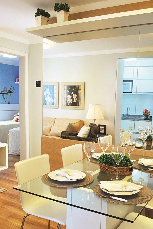 Pequenas salas de estar e jantar decorada com uma mesa de vidro e cadeiras brancas.