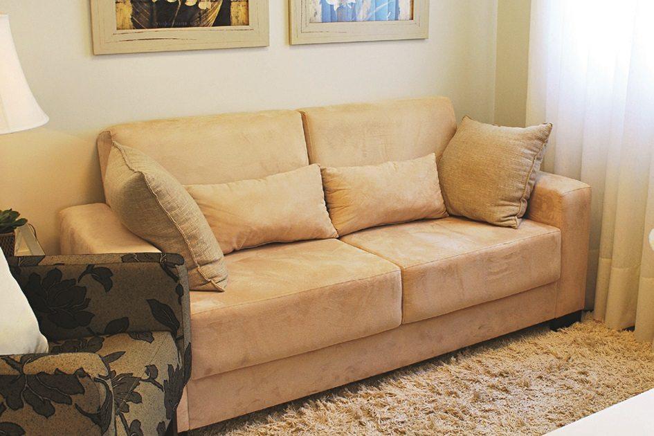 Pequenas salas com sofá bege e poltronas da mesma cor e, do lado esquerdo, uma poltrona marrom que destaca no cômodo.