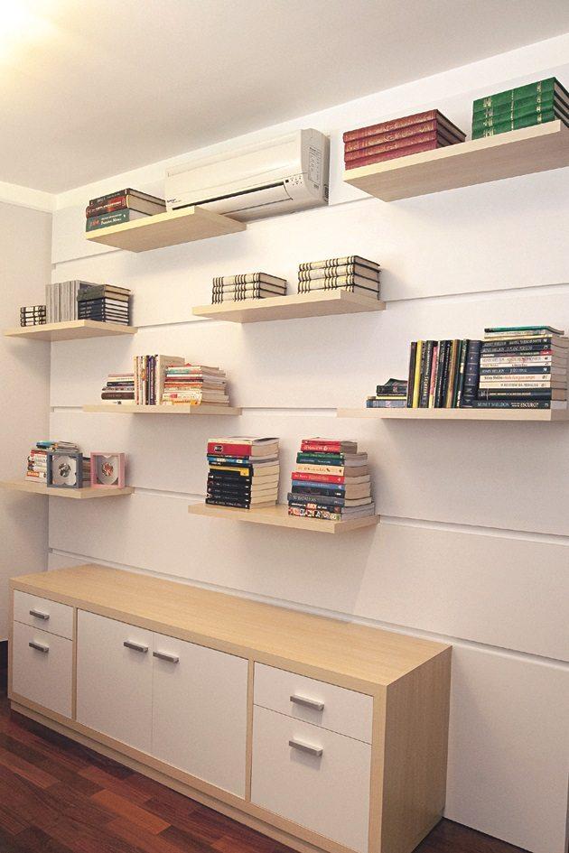 Trabalhe em casa com um espaço cheio de prateleiras que ajudam a organizar o ambiente que ficam encima de uma bancada de madeira branca.