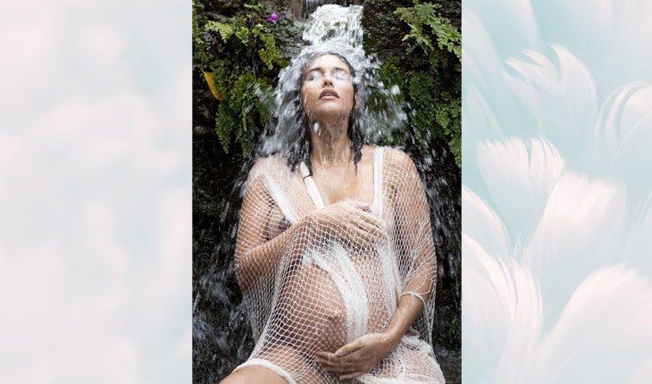 Debaixo de cachoeira, Debora Nacimento segura sua barriga de 9 meses