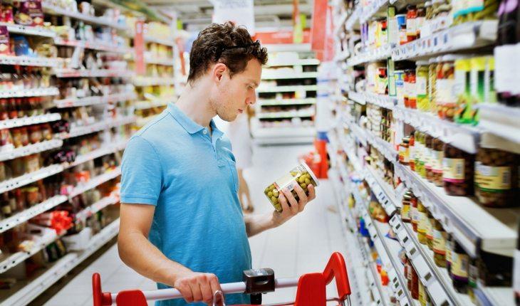 Homem escolhendo produto em supermercado