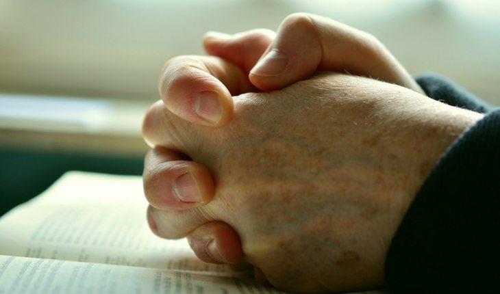 Mãos juntas em oração
