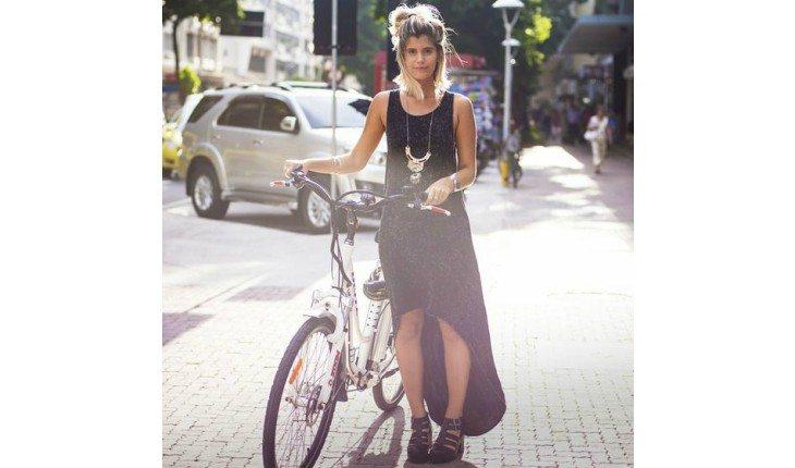 Mulher com bicicleta e vestido mullet preto.