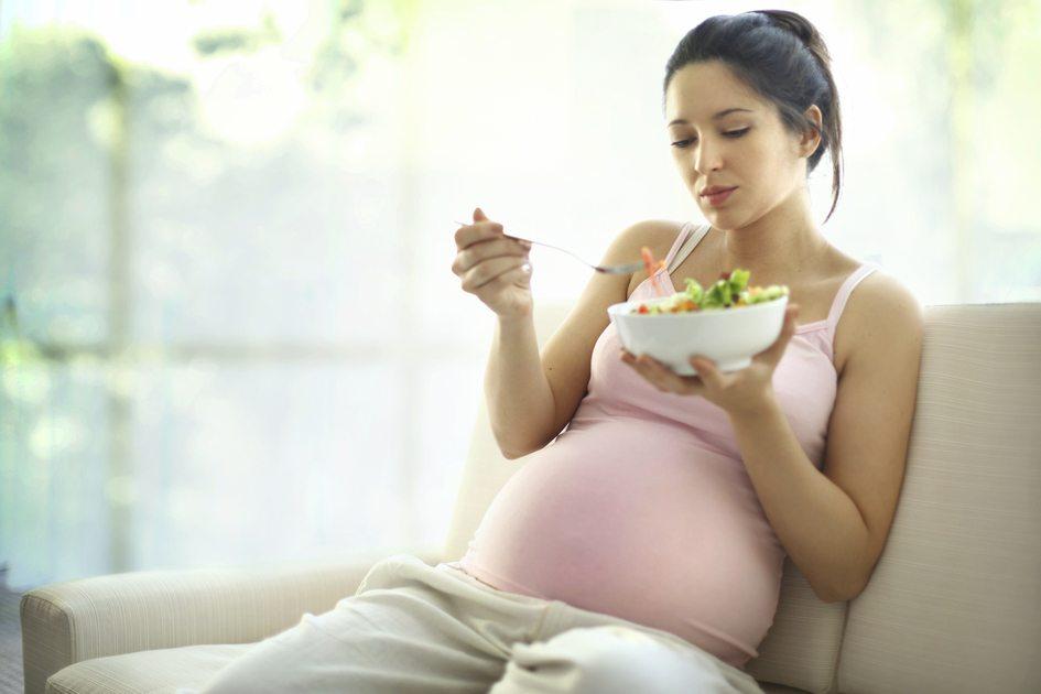Imagem de uma mulher grávida se alimentando representando a saúde da mulher