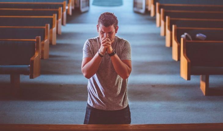 Homem orando na igreja