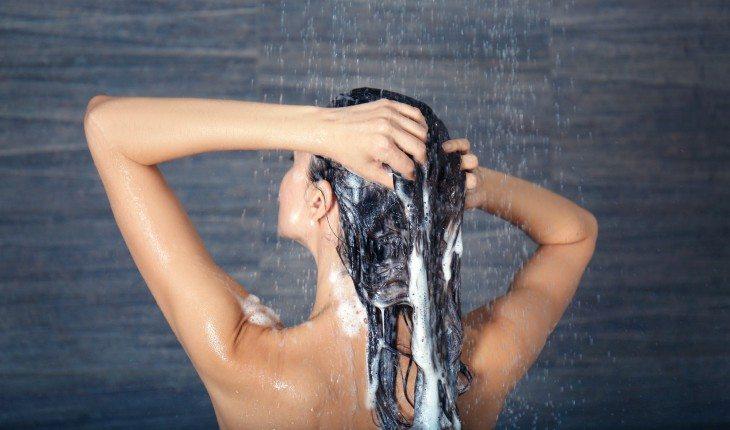 mulher lavando o cabelo no inverno com shampoo anti-residuos