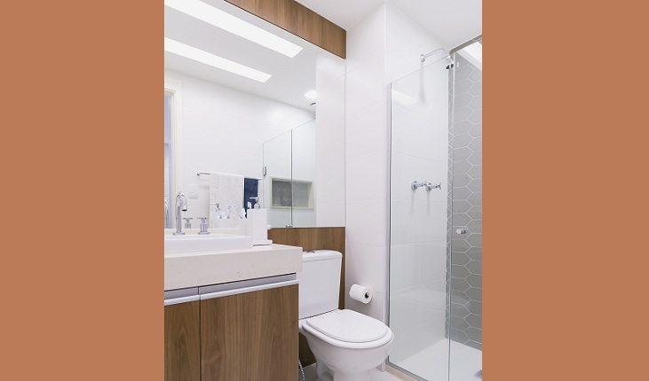 banheiro com laminado melamínico e espelhos e revestimento hexagonal na parede do boxe