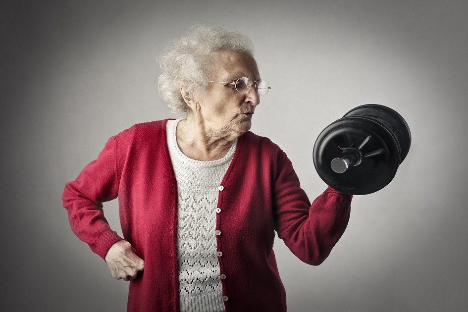 Mulher idosa com casaco vinho levantando peso