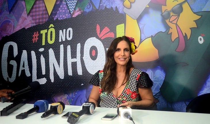 Cantora Ivete Sangalo sentada pronta para uma coletiva de imprensa