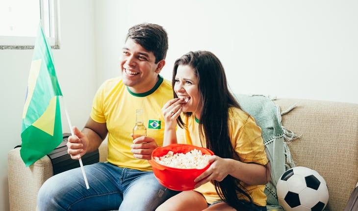 mulher comendo pipoca enquanto assiste o jogo do Brasil
