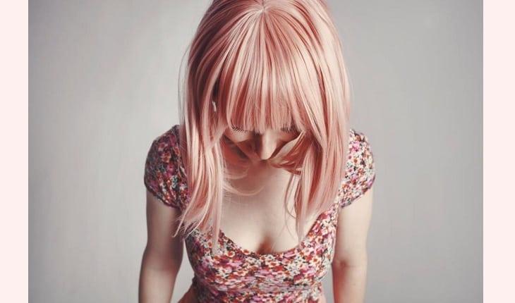 Mulher de cabelo rosa, comprido e franja