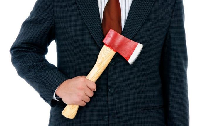 Homem de terno e gravata segurando machado de cabo de madeira e ponta vermelha e branca