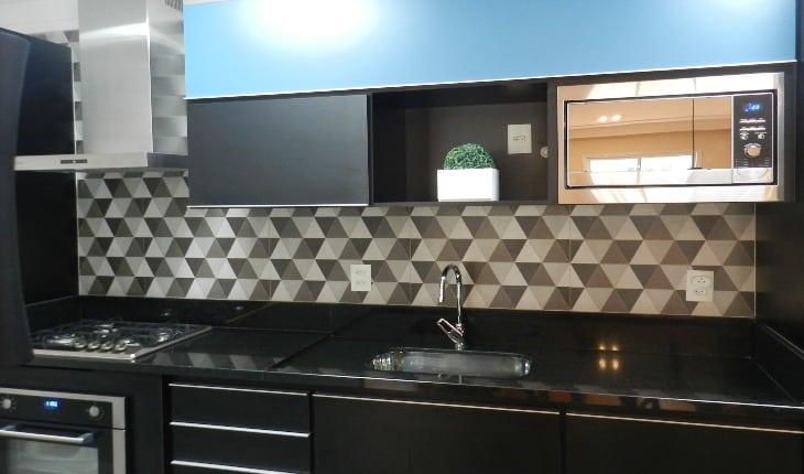Foto de uma cozinha com armários escuros em tom de preto e azul e revestimento geométrico branco e cinza