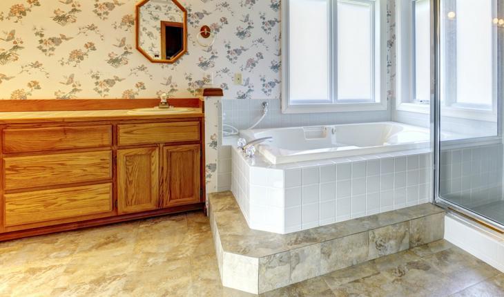 Banheiro com pia de madeira e banheira branca
