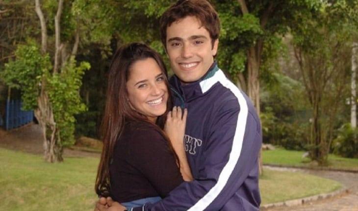 Casais de Malhação: Bernardo e Betina. Foto posada dos dois abraçados ao ar livre, com árvores ao fundo.