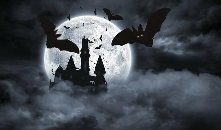 Morcegos sobrevoando castelo mal assombrado em noite de lua cheia