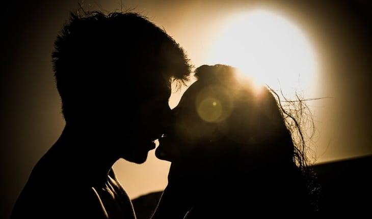 casal se beijando silhueta com sol ao fundo