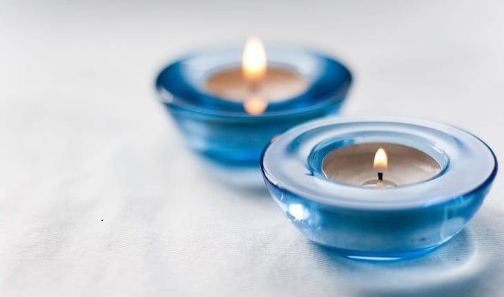 Imagem de três velas azuis para ilustrar post sobre simpatias para acabar com o ciúme