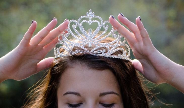 Rainha colocando tiara de brilhantes na cabeça